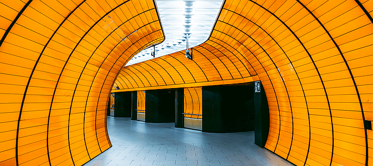 A long tunnel walkway in Munich, Germany. Its orange-tiled walls seem stark and purposeful.